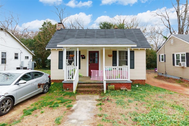 bungalow with a porch and cooling unit