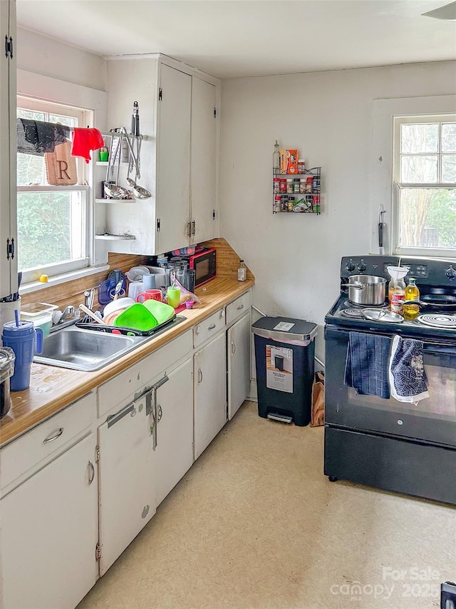 kitchen with white cabinetry, a healthy amount of sunlight, black range with electric stovetop, and sink