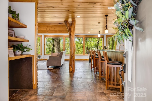 living area with recessed lighting, wooden ceiling, and stone tile flooring