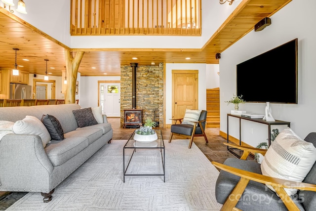 living area featuring recessed lighting, a wood stove, and a high ceiling