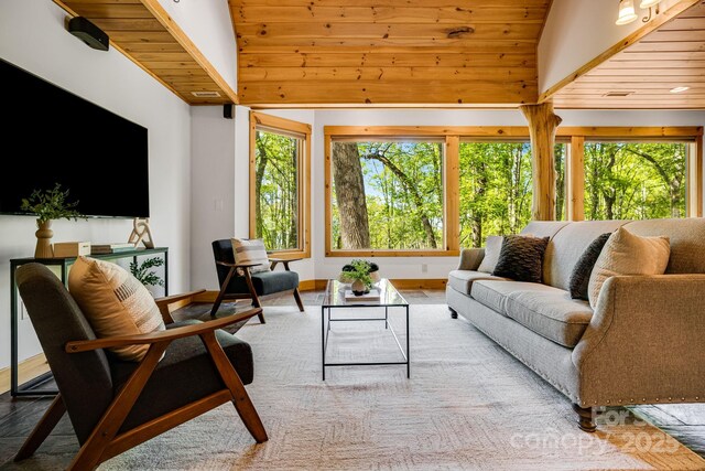 living area with wooden ceiling, baseboards, and high vaulted ceiling