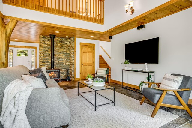 living area featuring a wood stove, stairs, recessed lighting, baseboards, and wood finished floors