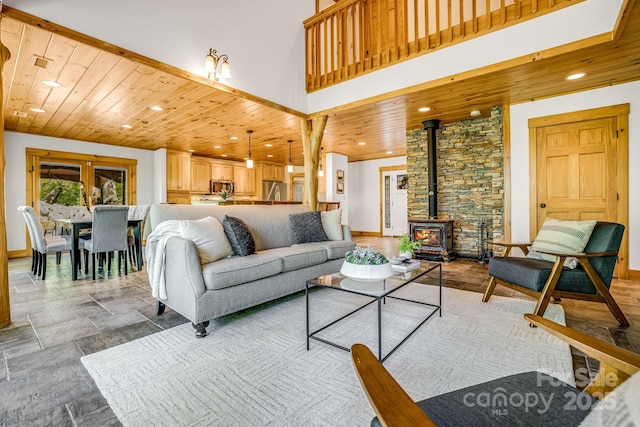living area featuring stone tile floors, baseboards, wooden ceiling, and a wood stove