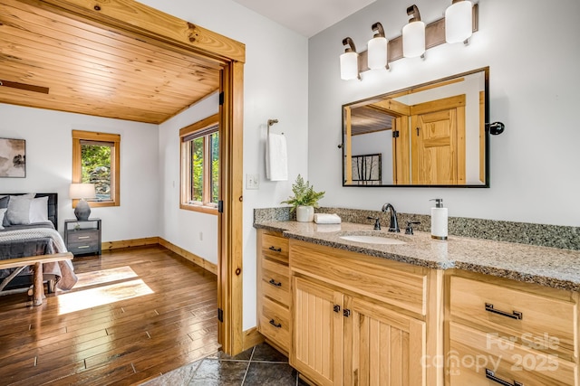 bathroom featuring baseboards, wood-type flooring, wooden ceiling, and vanity