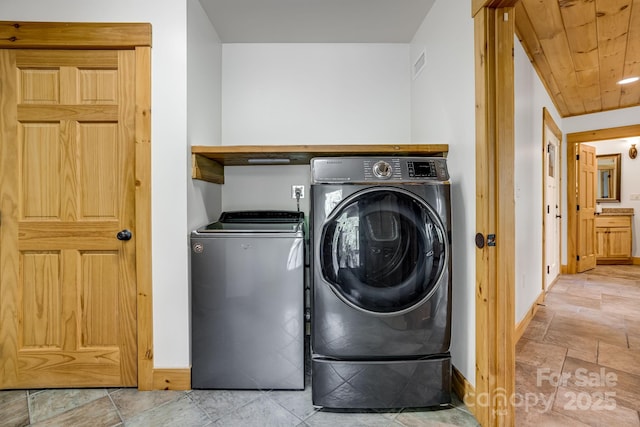 washroom with laundry area, stone finish flooring, visible vents, baseboards, and separate washer and dryer