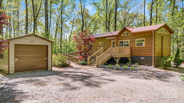 chalet / cabin featuring a garage, stairway, crawl space, an outdoor structure, and metal roof