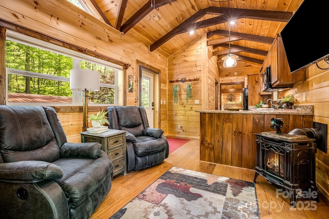 living room featuring lofted ceiling with beams, wood ceiling, and wooden walls