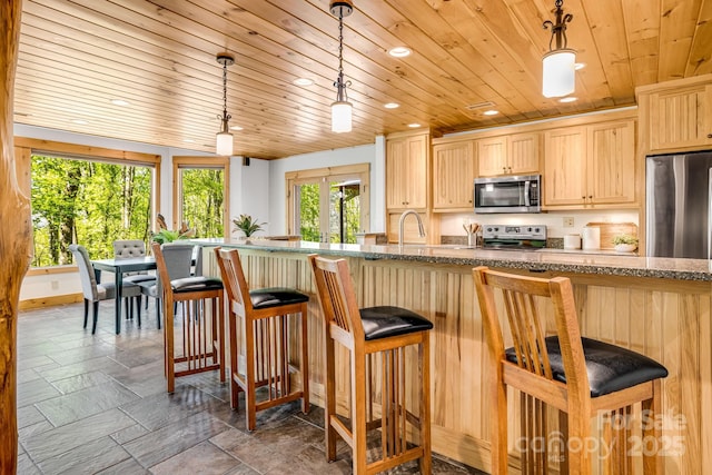 216 Log Gap Rd, Fairview, NC 28730 - kitchen with stainless steel appliances, light brown cabinetry, wood ceiling, recessed lighting, and a kitchen breakfast bar