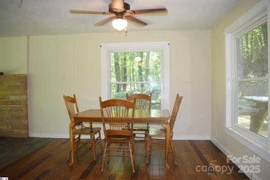 dining space with ceiling fan and dark hardwood / wood-style flooring