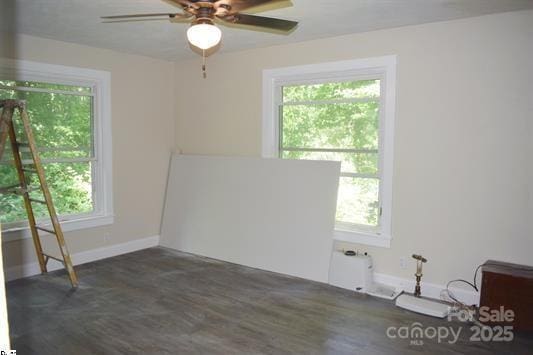 spare room featuring dark wood-type flooring and ceiling fan