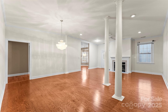 unfurnished living room featuring ceiling fan, ornamental molding, hardwood / wood-style floors, and ornate columns