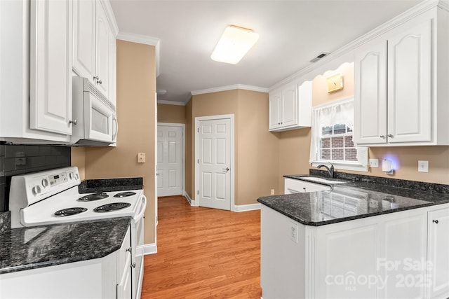 kitchen with crown molding, white cabinets, white appliances, and dark stone counters