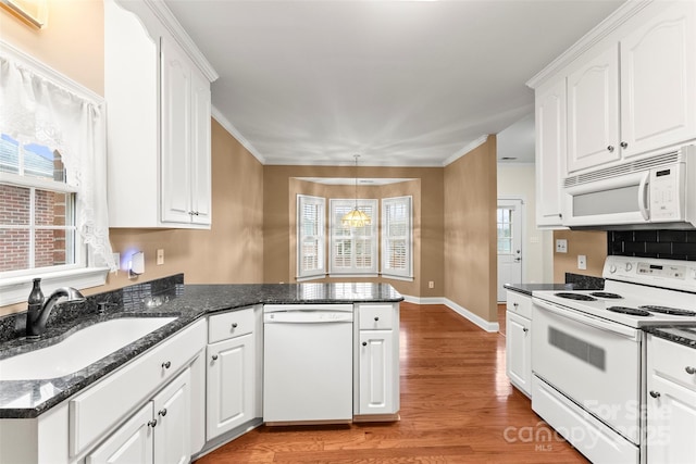 kitchen featuring white appliances, kitchen peninsula, sink, and white cabinets