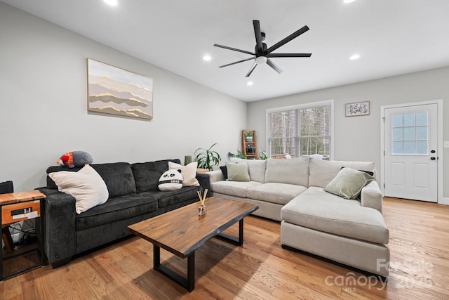 living room with ceiling fan and light hardwood / wood-style flooring