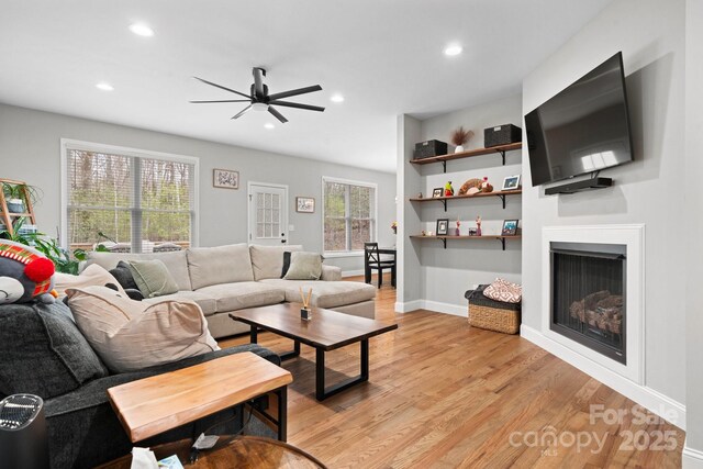 living room featuring ceiling fan and light hardwood / wood-style floors