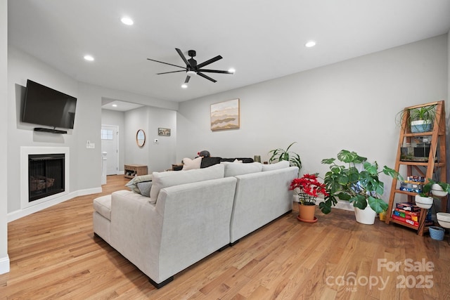 living room with ceiling fan and light hardwood / wood-style flooring