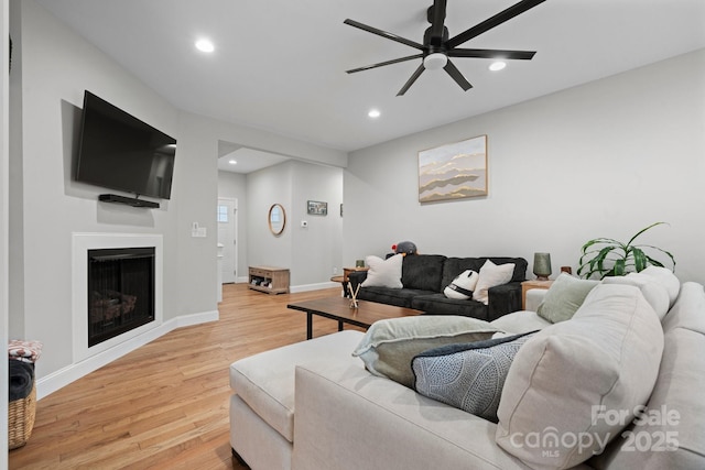 living room with light hardwood / wood-style floors and ceiling fan