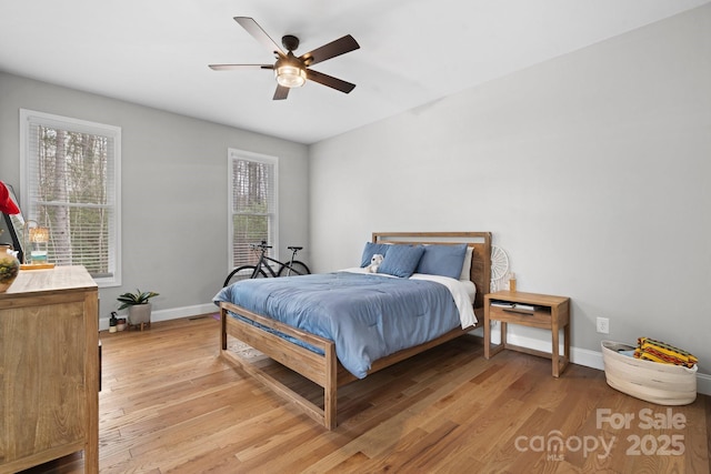 bedroom with multiple windows, light hardwood / wood-style flooring, and ceiling fan