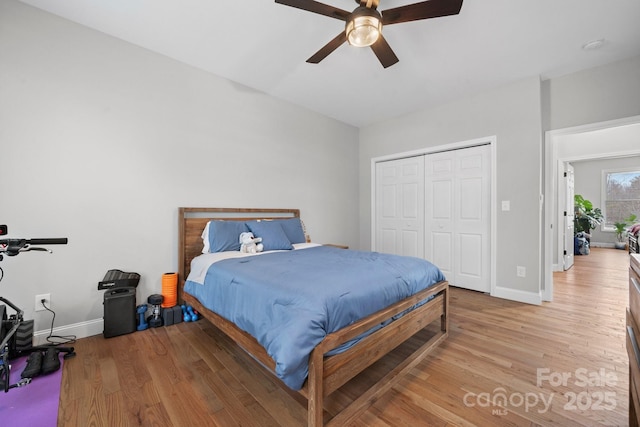 bedroom with ceiling fan, light wood-type flooring, and a closet