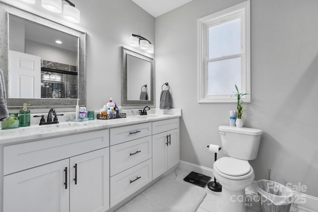 bathroom with vanity, a shower with door, and toilet