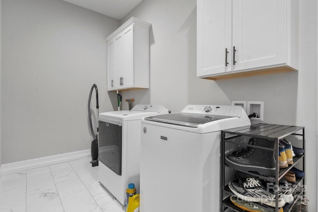 clothes washing area featuring cabinets and washer and dryer