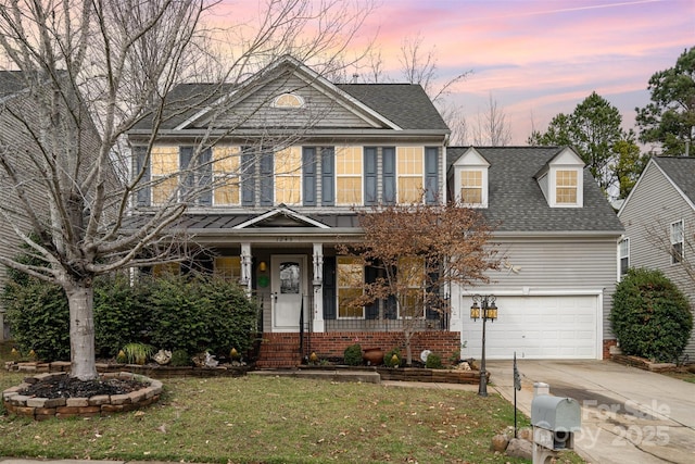 view of front facade with concrete driveway, a front yard, roof with shingles, covered porch, and an attached garage