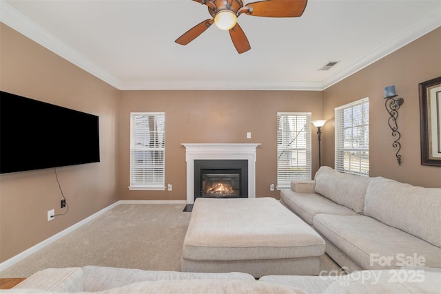 living room featuring ornamental molding, a fireplace with flush hearth, carpet flooring, ceiling fan, and baseboards