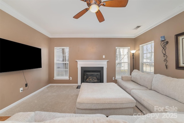 carpeted living area with ornamental molding, a fireplace with flush hearth, a ceiling fan, and baseboards