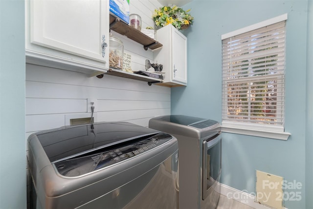 laundry area with washer and clothes dryer, cabinet space, and baseboards