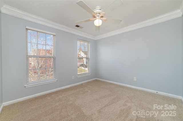 carpeted spare room with crown molding, baseboards, and a ceiling fan