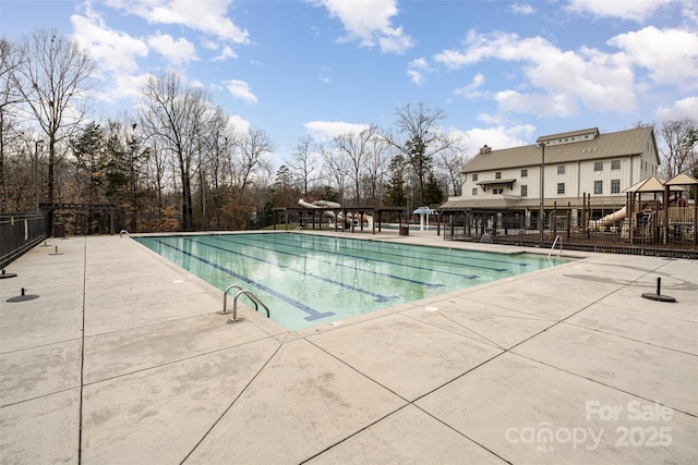 community pool with fence and a patio area