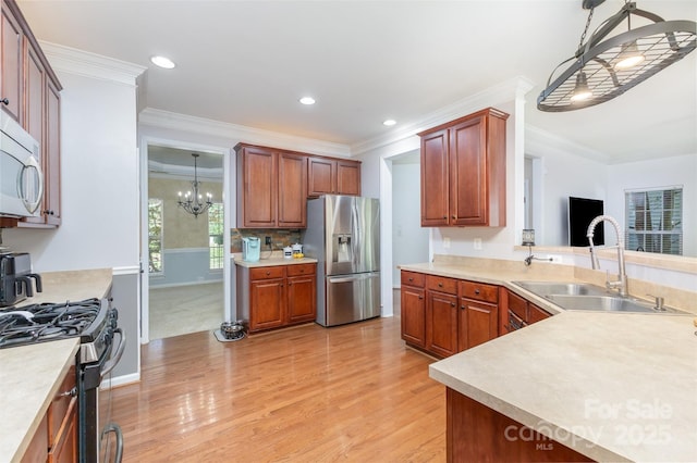 1245 Periwinkle Dr, Waxhaw, NC 28173 - kitchen with stainless steel appliances, light wood finished floors, a chandelier, light countertops, and ornamental molding