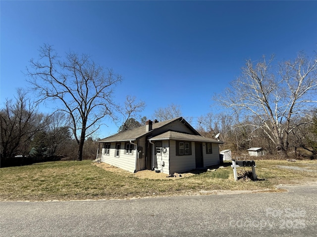 view of front of property featuring a chimney and a front yard