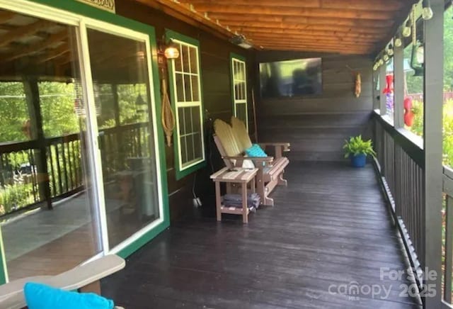 sunroom featuring vaulted ceiling and wooden ceiling