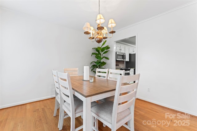 dining area featuring crown molding, an inviting chandelier, and light hardwood / wood-style floors