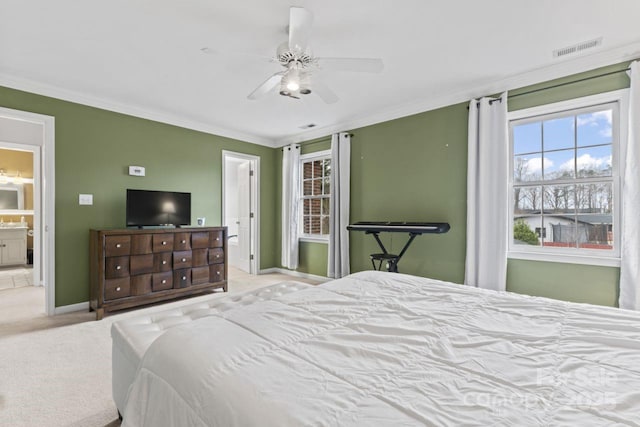 carpeted bedroom with ornamental molding, ceiling fan, and ensuite bath