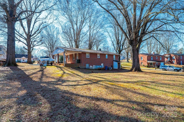 view of side of home featuring a yard and covered porch