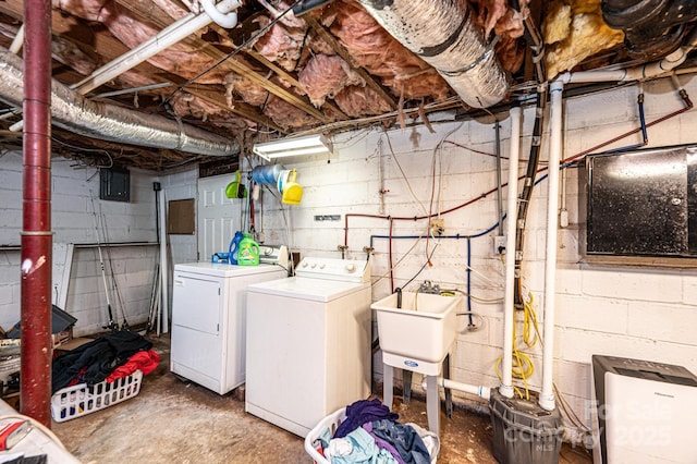 basement featuring independent washer and dryer, electric panel, and sink