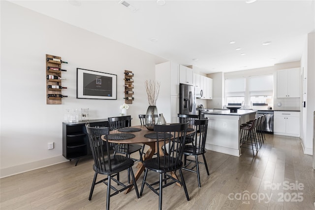 dining room featuring sink and light hardwood / wood-style floors