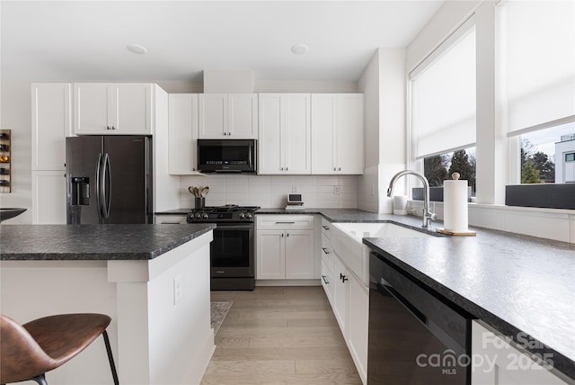 kitchen featuring sink, fridge with ice dispenser, gas range, white cabinetry, and dishwasher