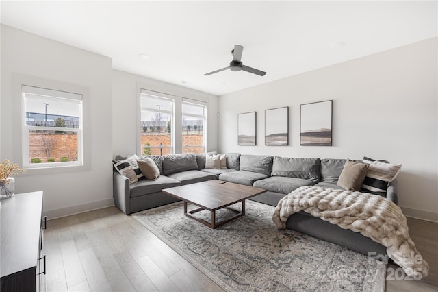 living room featuring ceiling fan, plenty of natural light, and light hardwood / wood-style floors