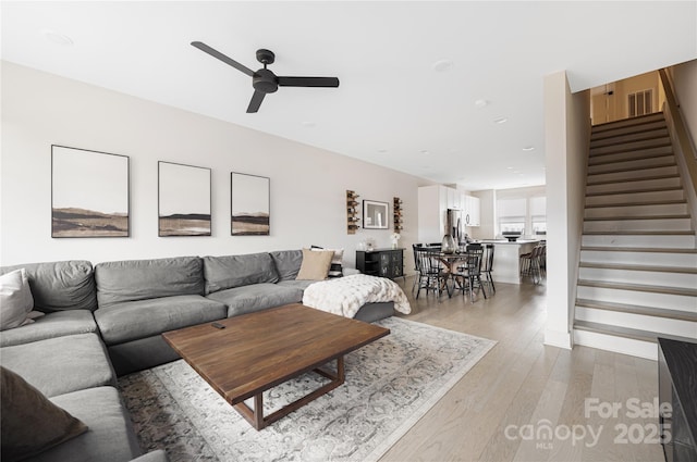 living room with light hardwood / wood-style floors and ceiling fan