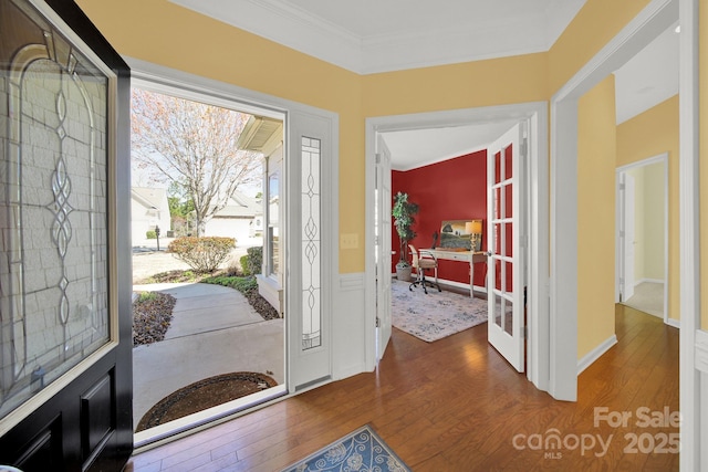 foyer entrance with crown molding and wood-type flooring