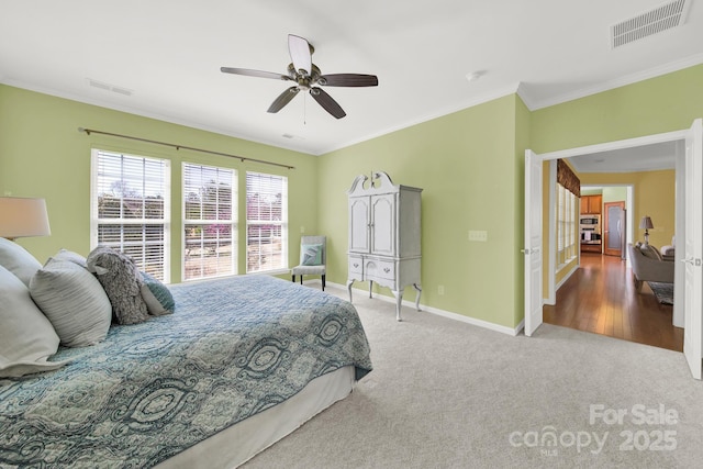 bedroom featuring baseboards, visible vents, crown molding, and carpet floors