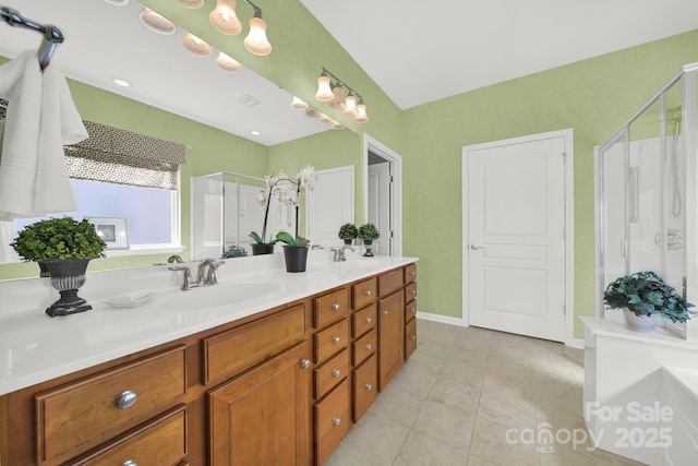 full bath with a stall shower, double vanity, tile patterned flooring, and a sink