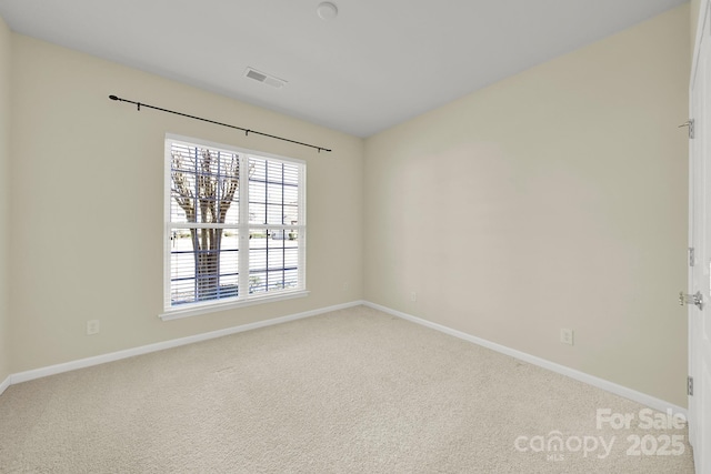 carpeted spare room with baseboards and visible vents