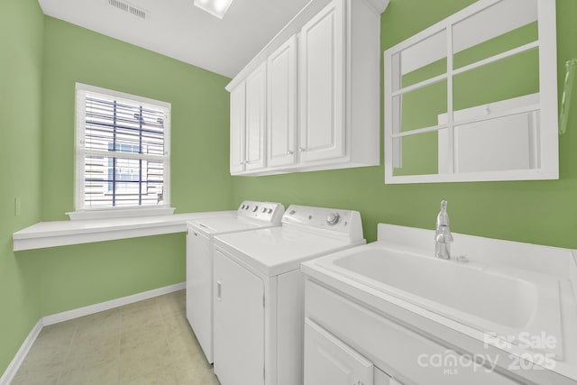 laundry room with visible vents, baseboards, a sink, washer and dryer, and cabinet space