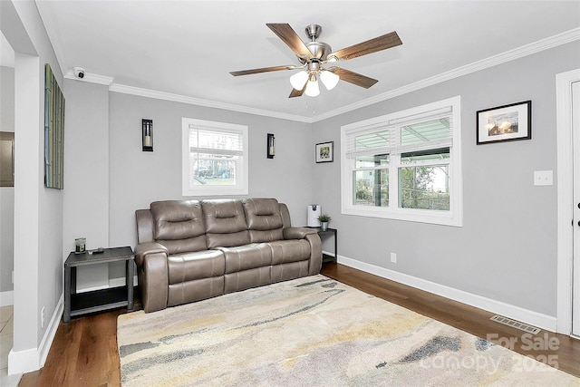 living room with crown molding, dark hardwood / wood-style floors, and ceiling fan