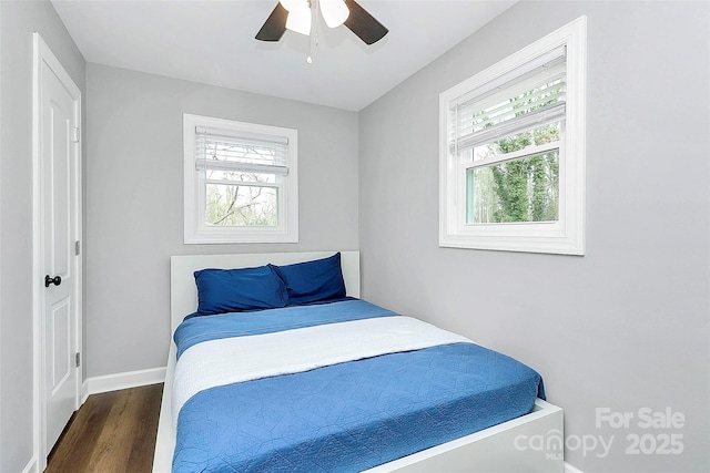 bedroom with ceiling fan, dark hardwood / wood-style floors, and multiple windows