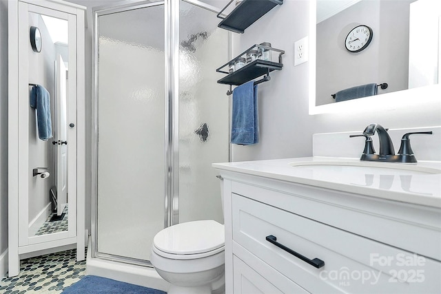 bathroom featuring vanity, toilet, and a shower with shower door